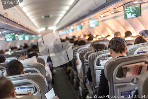 Image of Interior of airplane with passengers on seats waiting to taik off.