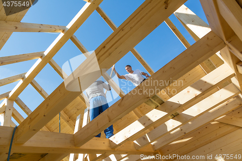 Image of Builders at work with wooden roof construction.