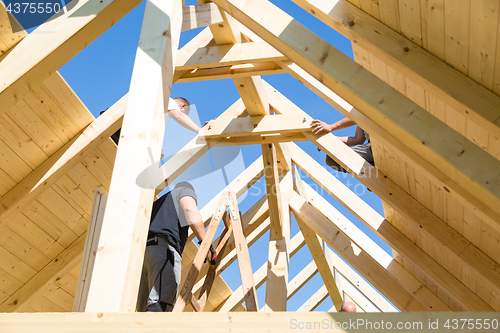 Image of Builders at work with wooden roof construction.