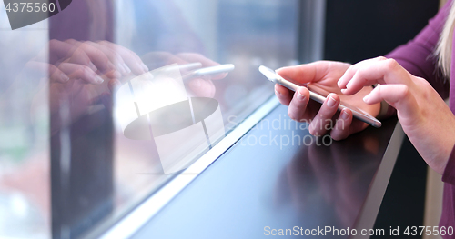 Image of Close up of business woman using cell phone in office interior