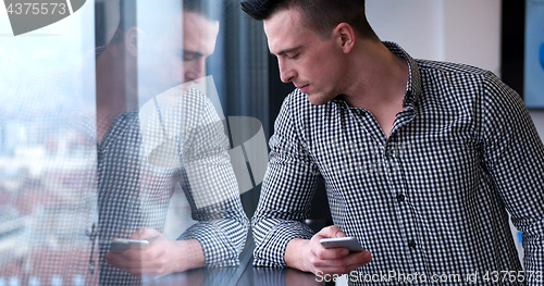 Image of Business Man Talking On Cell Phone, Looking Out Office Window