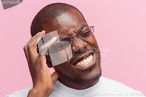 Image of Black man holding his head in pain and depression