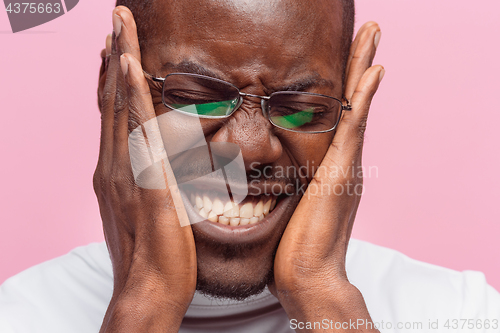 Image of Black man holding his head in pain and depression