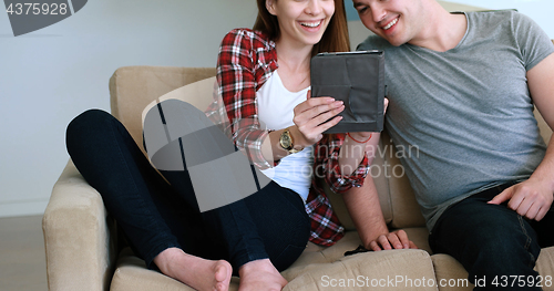 Image of Young Couple using digital tablet at home