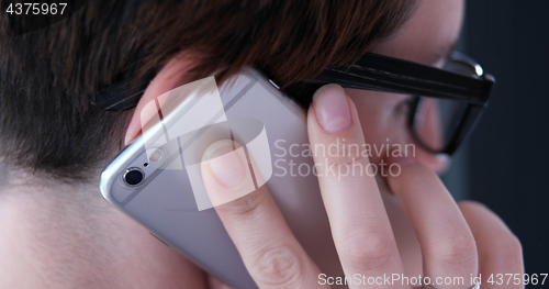 Image of Elegant Woman Using Mobile Phone by window in office building