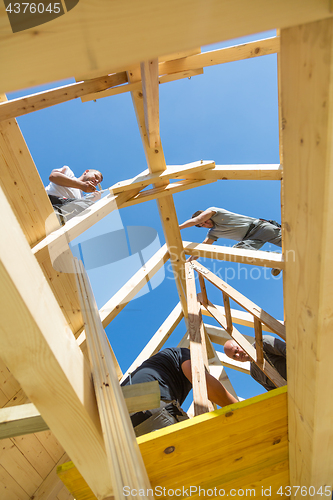 Image of Builders at work with wooden roof construction.