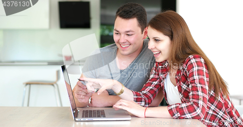 Image of Couple Using Laptop To Shop Online in modern apartment