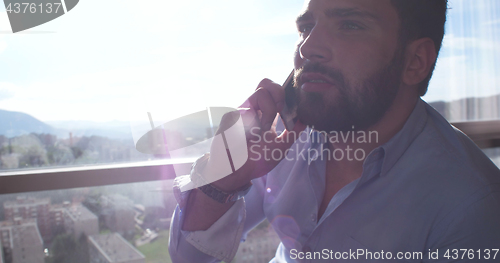 Image of Business Man Talking On Cell Phone At Home