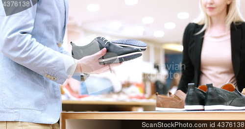 Image of Man Chooses Shoes At Shoe Store