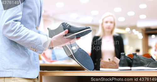 Image of Man Chooses Shoes At Shoe Store