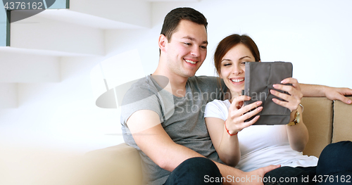 Image of Young Couple using digital tablet at home