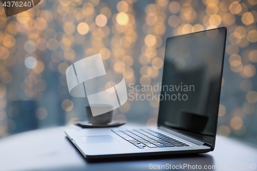 Image of laptop and coffee cup on table at christmas