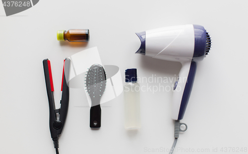 Image of hairdryer, brush, hot styling hair spray and iron