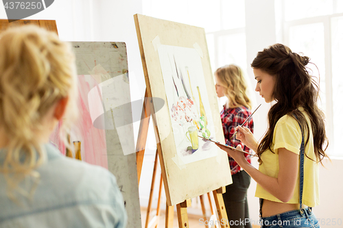 Image of woman with easel painting at art school studio