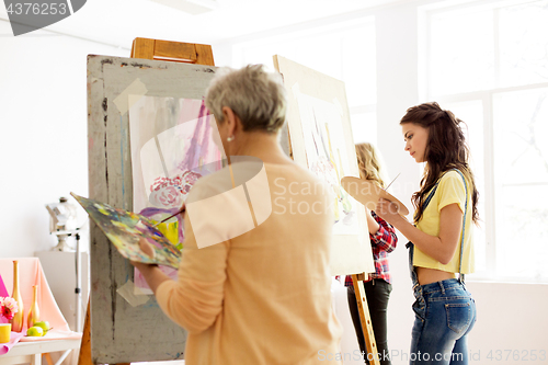 Image of senior woman painting at art school studio