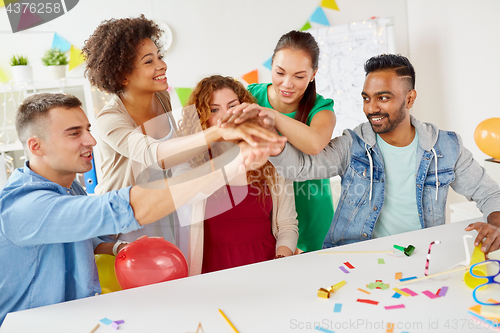 Image of happy business team at office party holding hands