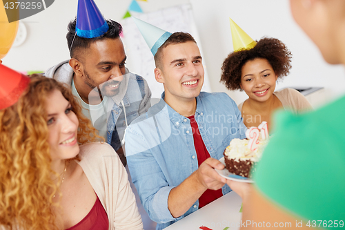 Image of team greeting colleague at office birthday party