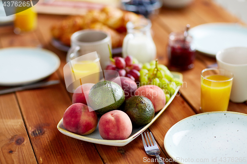 Image of fruits, juice and other food on table at breakfast