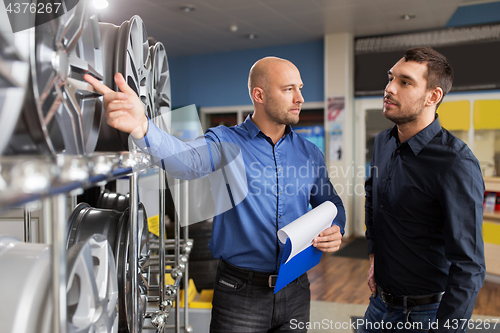 Image of customer and salesman at car service or auto store