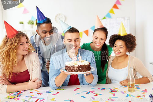 Image of team greeting colleague at office birthday party