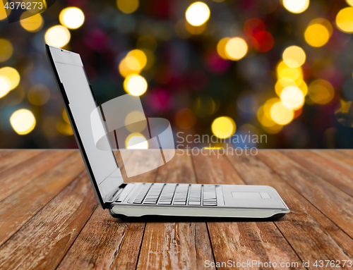 Image of laptop computer over christmas lights