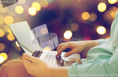 Image of close up of man typing on laptop keyboard