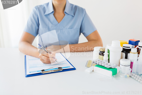 Image of doctor with medicines and clipboard at hospital