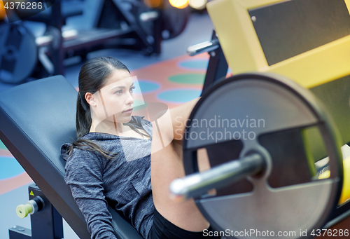 Image of woman flexing muscles on leg press machine in gym