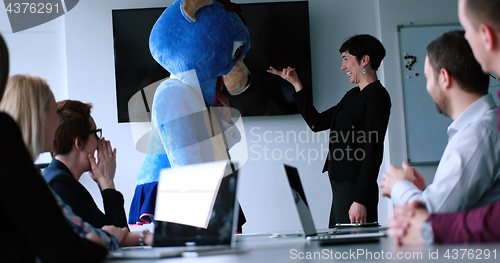 Image of boss dresed as bear having fun with business people in trendy of