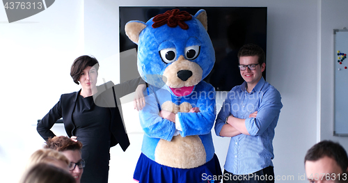 Image of boss dresed as bear having fun with business people in trendy of