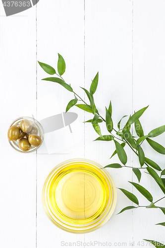 Image of Olive oil and olive branch on the wooden table