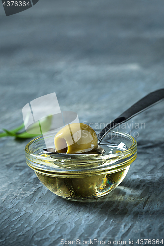 Image of Olive oil and olive branch on the wooden table