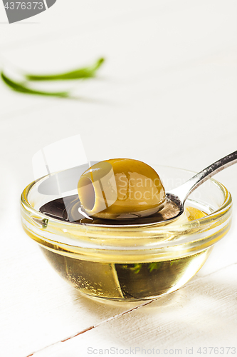 Image of Olive oil and olive branch on the wooden table