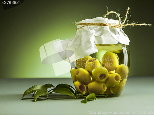 Image of Olive oil and olive branch on the wooden table