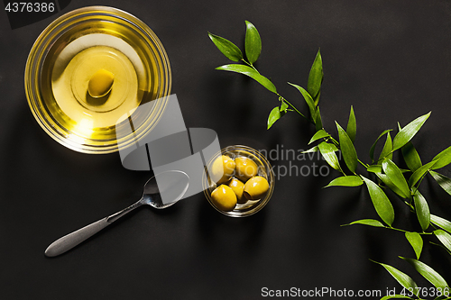 Image of Olive oil and olive branch on the wooden table