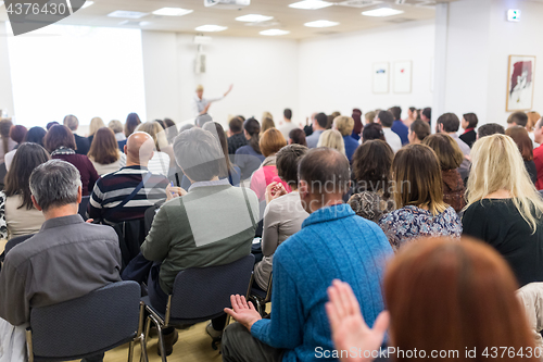 Image of Woman giving interactive motivational speech at entrepreneurship workshop.