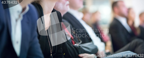 Image of Row of business people sitting at seminar.