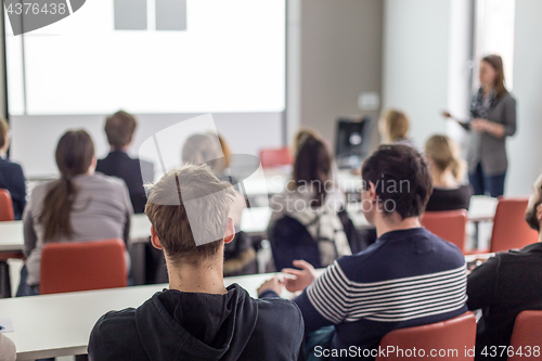 Image of Woman giving presentation in lecture hall at university.