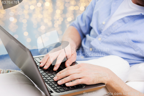 Image of close up of man typing on laptop keyboard