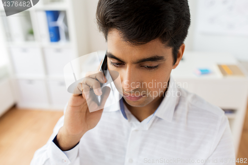 Image of businessman calling on smartphone at office