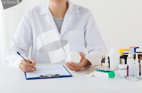 Image of doctor with medicines and clipboard at hospital