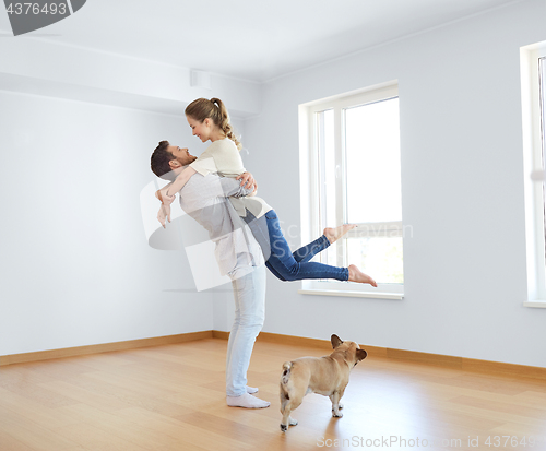 Image of happy couple at empty room of new home