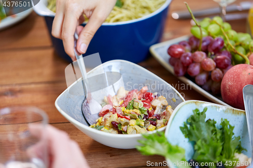 Image of people eating salad at table with food