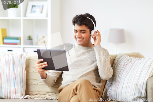 Image of man in phones with tablet pc listening to music