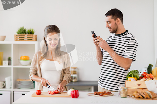 Image of happy couple cooking food at home kitchen