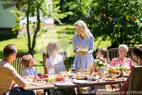 Image of happy family having dinner or summer garden party