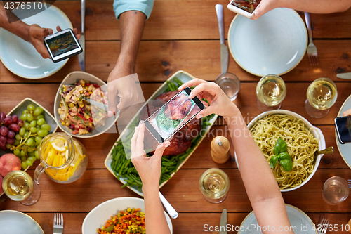 Image of people with smartphones photographing food