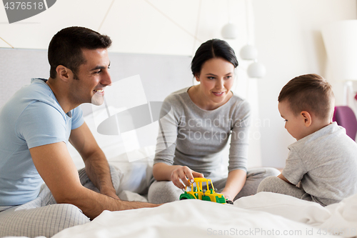 Image of happy family in bed at home or hotel room