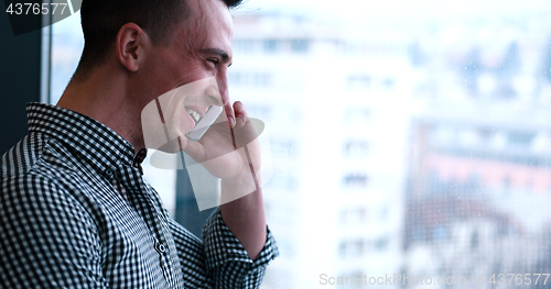 Image of Business Man Talking On Cell Phone, Looking Out Office Window