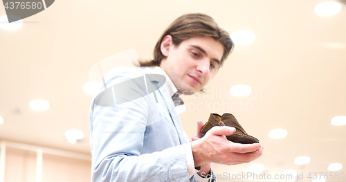 Image of Man Chooses Shoes At Shoe Store